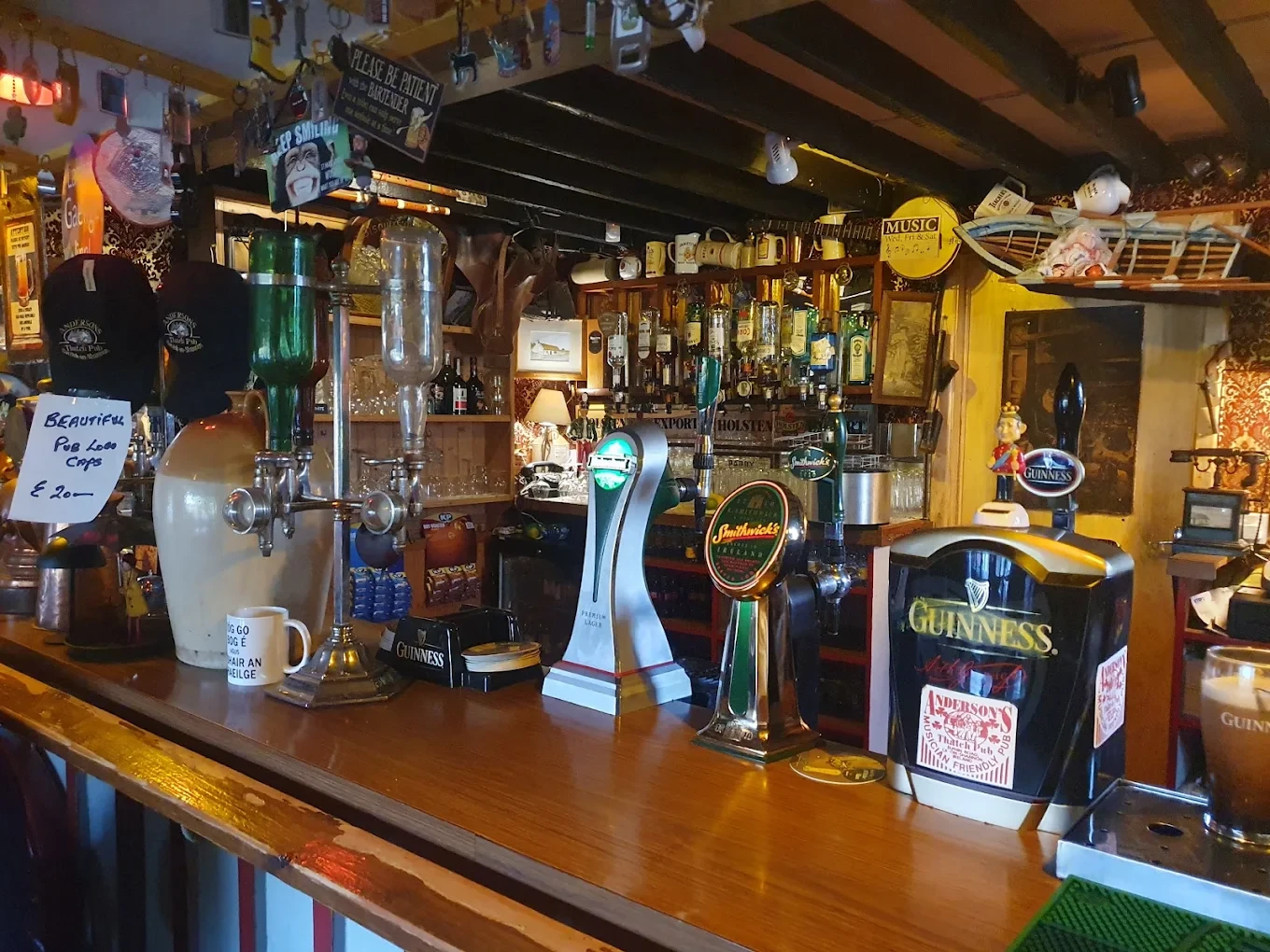 The bar at Anderson's Thatch Pub — Guinness taps, memorabilia and low timber ceilings